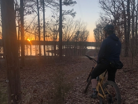 Person looking out at lake from mountain biking trails in in Jonesboro, Arkansas.