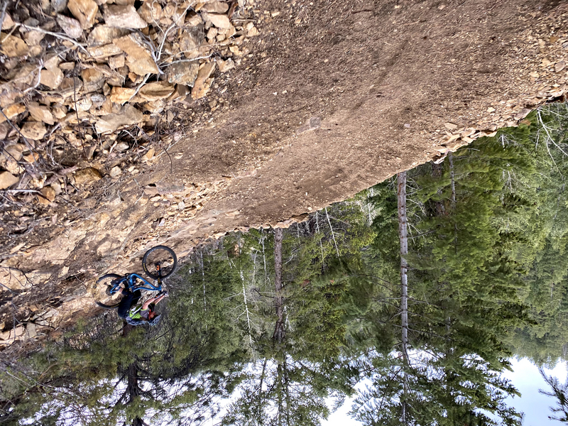 "Rider going down hill on a rocky section of trail"
