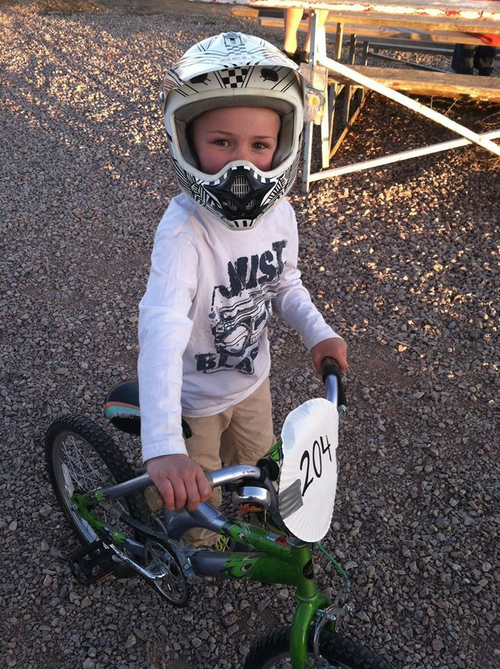 "Adam in a full face helmet holding his BMX"