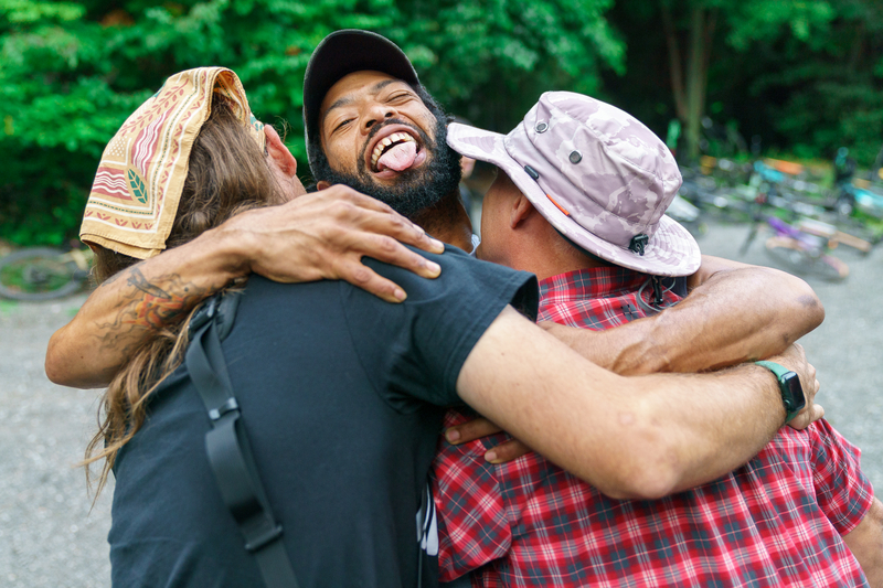 "Three mountain bikers hugging after a day of racing"