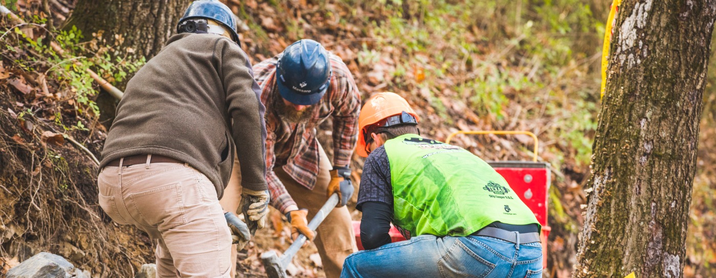 Three people building trail, funded by IMBA's Dig In program.