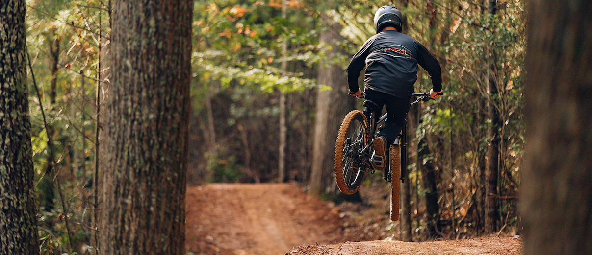 Kid riding mountain bike, catching air.