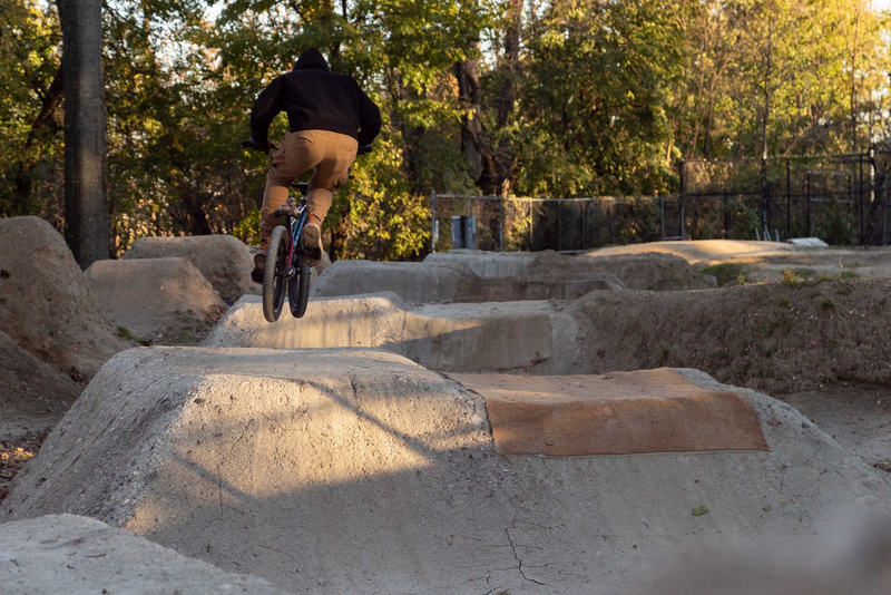 "A mountain biker from behind riding the jump park in Highbridge"