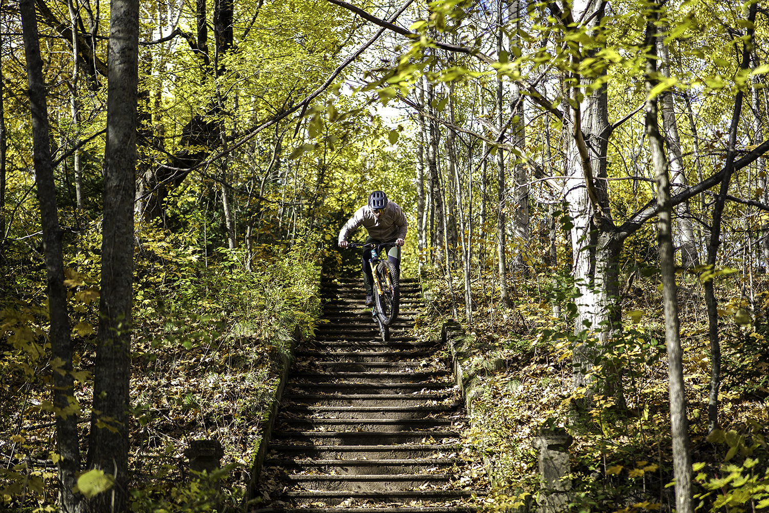 "Brice Shirbach riding down a set of concrete stairs in the woods."