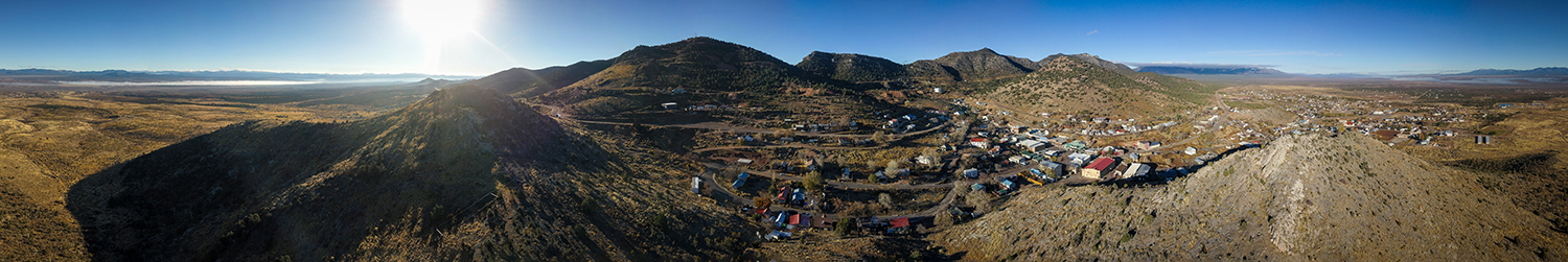 "Aerial view of the town of Pioche, Nevada. Clear blue sky with small mountains hugging in the small town."