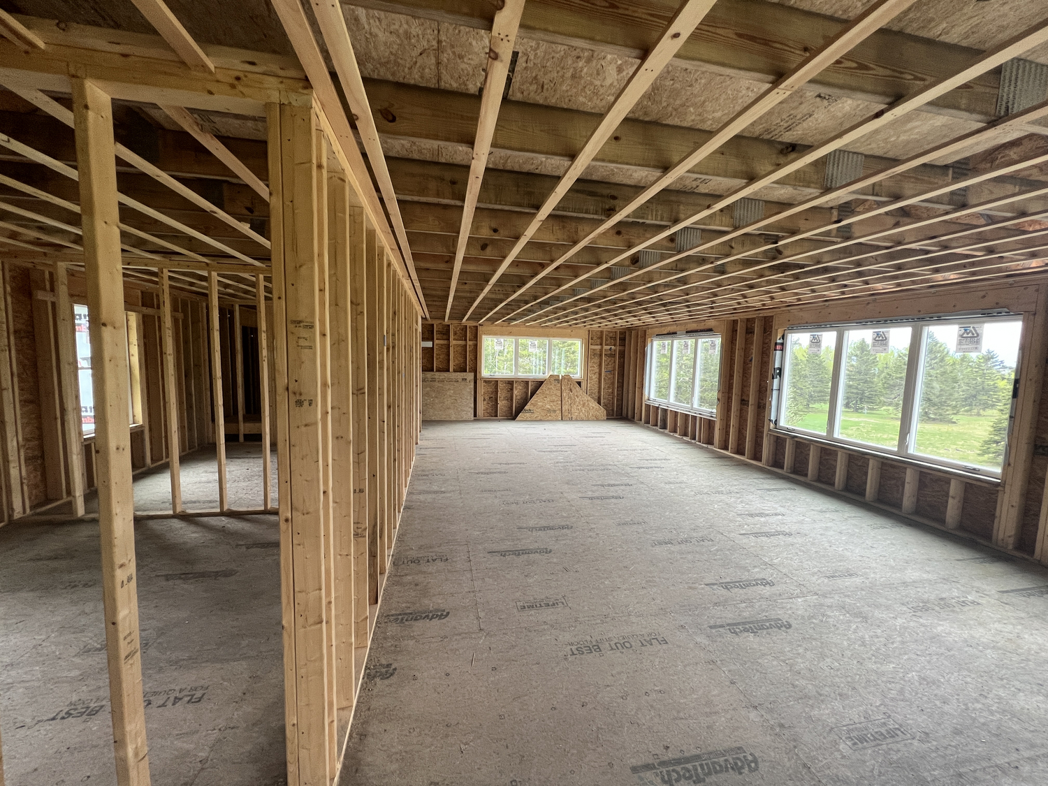 "A building interior with only studs and plywood "