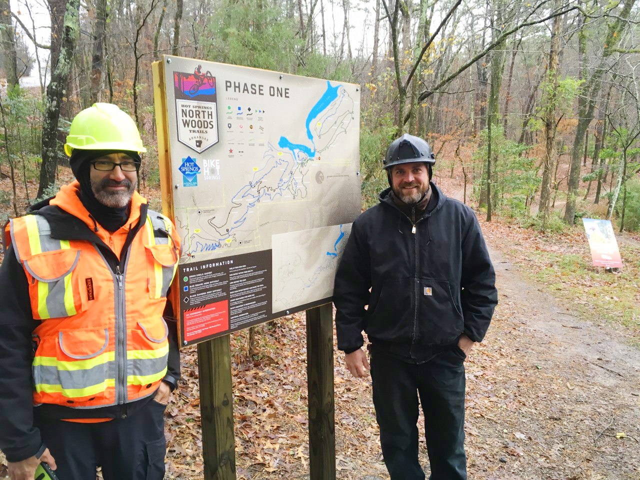 "Former IMBA Director of Construction Rich Edwards with current IMBA Director of Construction & Operations Josh Olson posing near a Northwoods Trails kiosk."