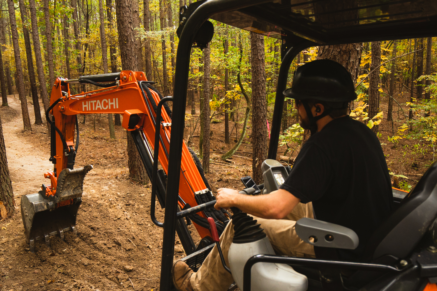 IMBA Trail Solutions Josh Olson using a mini-excavator.