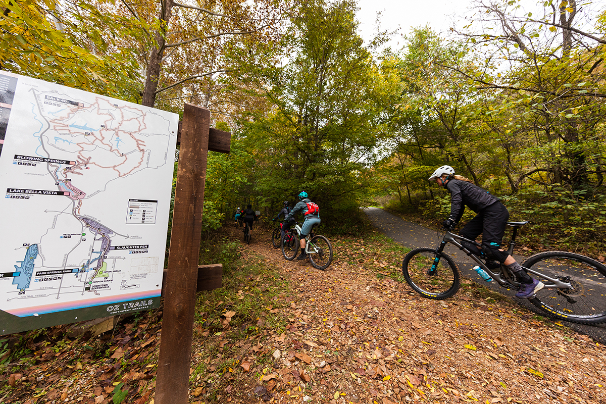 Mountain bikers riding past trail signage