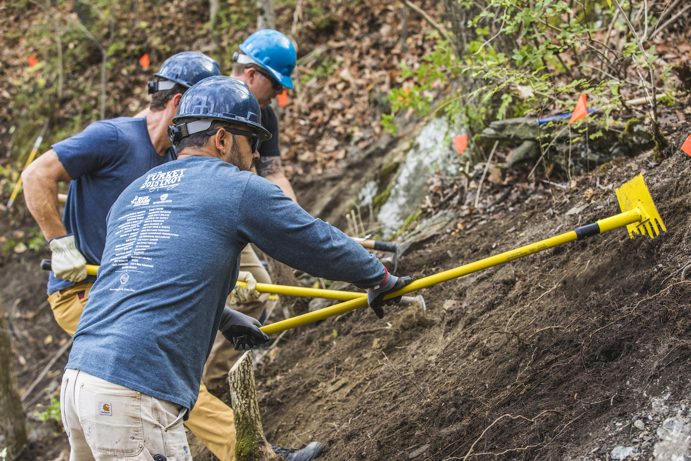 Three people building trail, funded by IMBA's Dig In Program