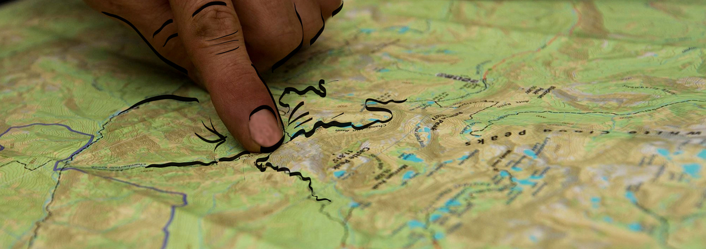 Person pointing to a location on a topo map, illustrated