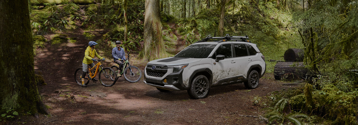 two mountain bikers chat at a trailhead