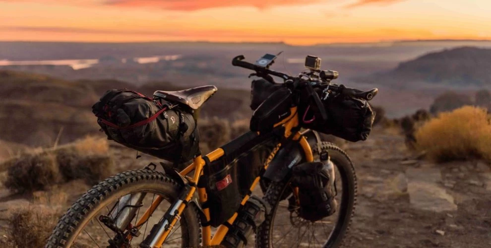 Bike with backpacking gear with a desert sunset background