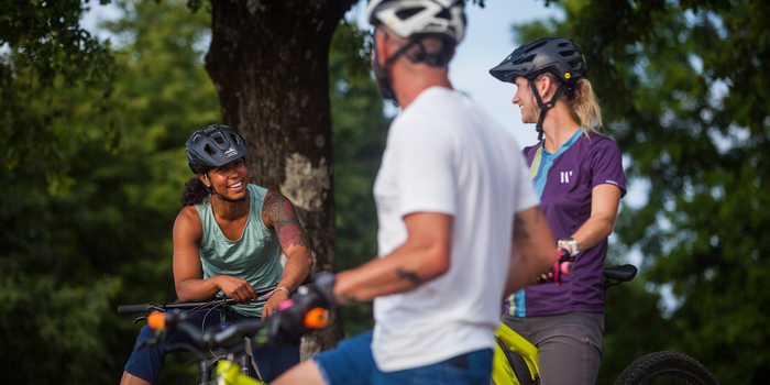 Three mountain bikers talking mid-ride.