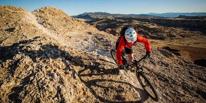 Mountain biker riding on single track in desert environment. 