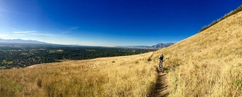 Rider on prairie sideslope of Bonneville Shoreline Trail overlooking Salt Lake Valley