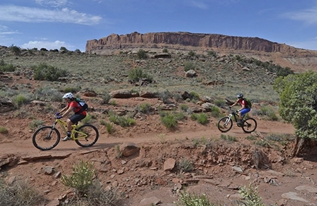 Two people riding mountain bikes in desert