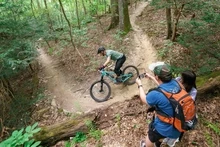A racer riding down a trail while spectators watch