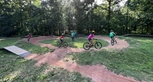 Youth riders doing laps on a dirt pump track in Brookfield Park