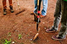 Three people with books and tools ready for a trail work day 